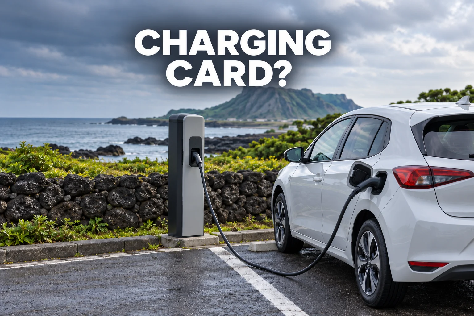 An electric hatchback connected to a charging pedestal beside a coastal stone wall, with the editorial text CHARGING CARD?
